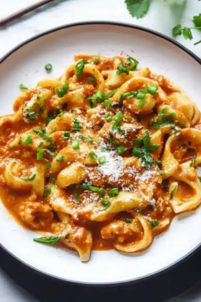 Penne-Pasta in einer cremigen Tomatensauce, garniert mit frischem Basilikum und Parmesan.